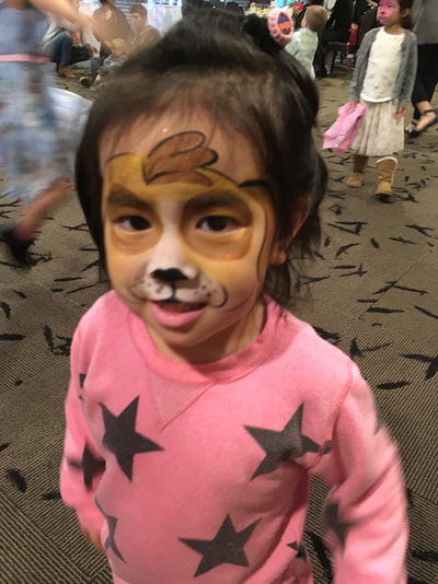 A little girl wears cute puppy face paint