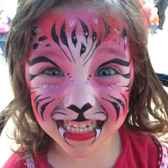 Little girl with pink sparkly tiger face paint